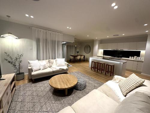 una sala de estar con un sofá y una mesa en Saltwater House - Opposite the Beach!, en South West Rocks