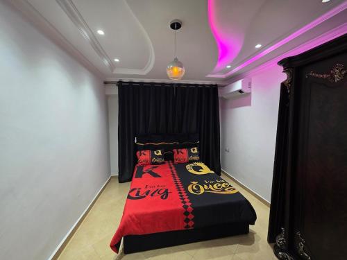 a bedroom with a bed with a red and black blanket at Apparte Tétouan Climatisé 2 Chambre et Securisé in Tetouan