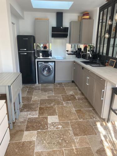 une cuisine avec un réfrigérateur et un lave-vaisselle dans l'établissement T2 au cœur de la Provence, à Aubagne