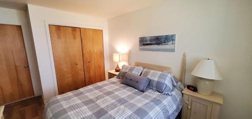 a bedroom with a bed and a lamp on a table at Woods Village 43 in Killington