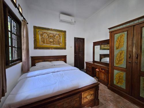 a bedroom with a large bed and a mirror at Nirun Garden Villa - Balinese Traditional House in North Bali in Ambengan