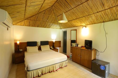 a bedroom with a bed and a flat screen tv at Rangauti Resort in Binesri