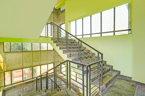 a spiral staircase in a building with windows at Hotel O Ranipet Vellore formerly Ars Residency in Pallikondai