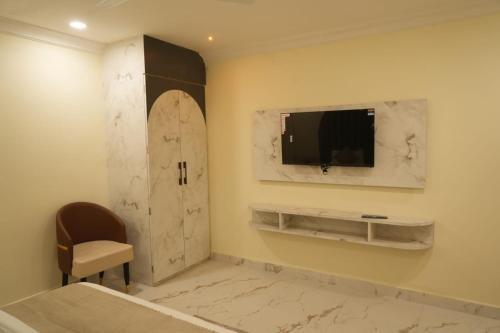 a hotel room with a tv and a bed at Blackout Bar & Hotel in Hanumāngarh Junction