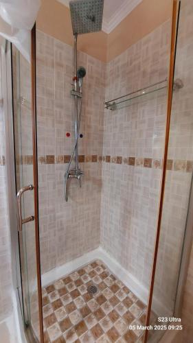 a shower with a glass door in a bathroom at Comfort Palace Guest House Kasane in Kasane