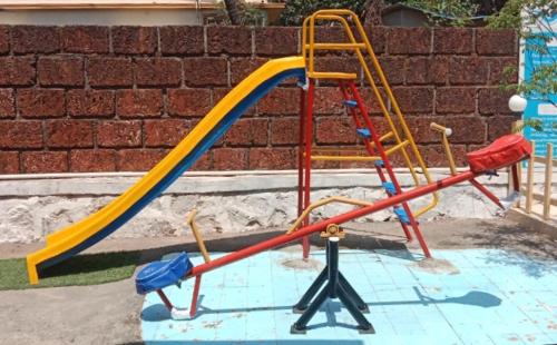 a playground with a slide in a yard at Salil farm Resort Nagaon in Alibaug