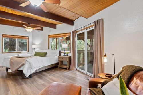 ein Schlafzimmer mit einem Bett und einem Balkon in der Unterkunft Cozy Owl Lodge, Central AC & Hea, Spa Tub & BBQ in Lake Arrowhead