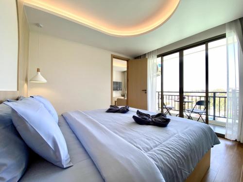 a bedroom with a large bed with a large window at Fantasea Condo - Kamala in Kamala Beach