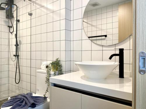 a bathroom with a white sink and a mirror at Fantasea Condo - Kamala in Kamala Beach
