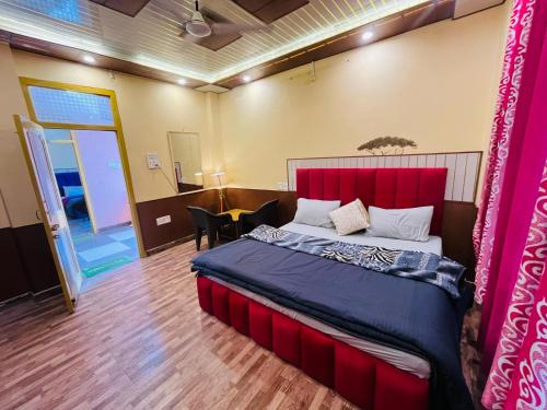 a bedroom with a large bed with a red headboard at Wood packers in Kasol