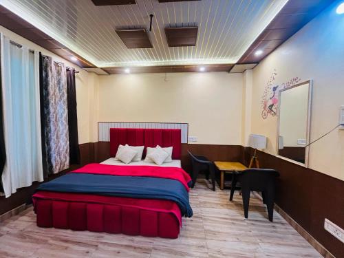 a bedroom with a red bed and a table at Wood packers in Kasol