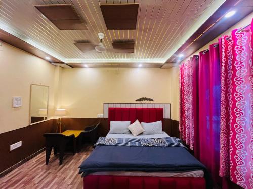 a bedroom with a bed with pink drapes at Wood packers in Kasol