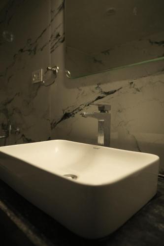 KālwāraChandraprabha Signature Resort Jaipur的浴室里有一面镜子的白色水槽