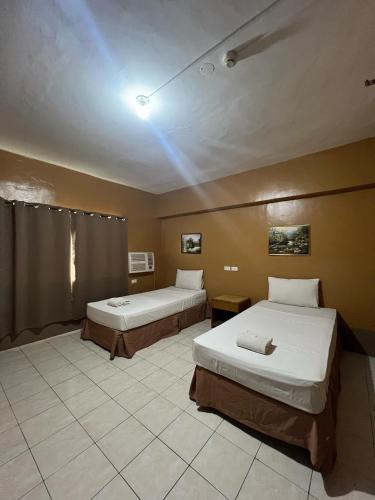 a room with two beds and a ceiling with at Doña Mercedes in Cebu City
