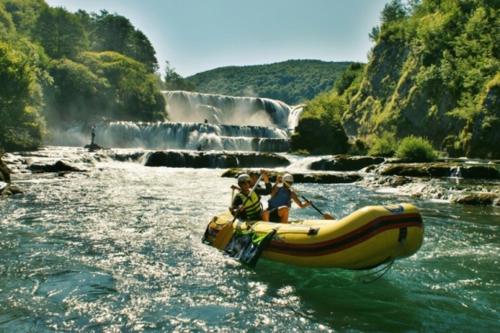 a group of people riding in a raft in a river at Auto Kamp Lav in Kulen Vakuf