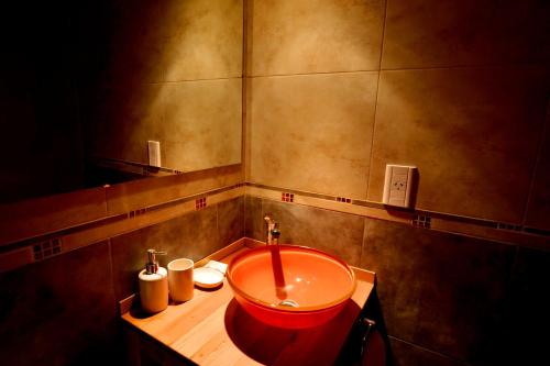 baño con lavabo rojo y espejo en Latitud 49 Apart en El Chaltén