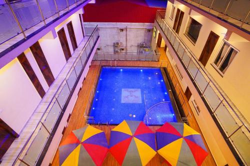 an overhead view of a swimming pool with colorful umbrellas at Elegant Beach Resort in Mandarmoni