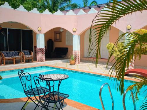 a swimming pool with a table and chairs next to a house at Villa Sajuri Homestay Sg Sembilang in Jeram