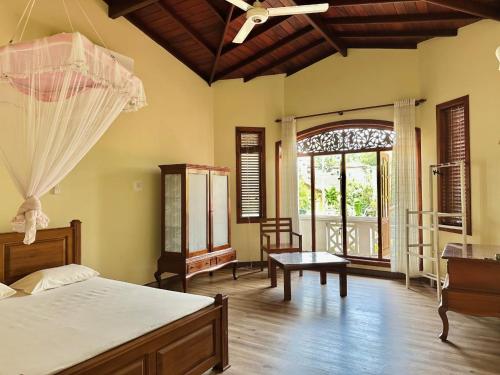 a bedroom with a bed and a large window at Sujee Villa White House in Beruwala