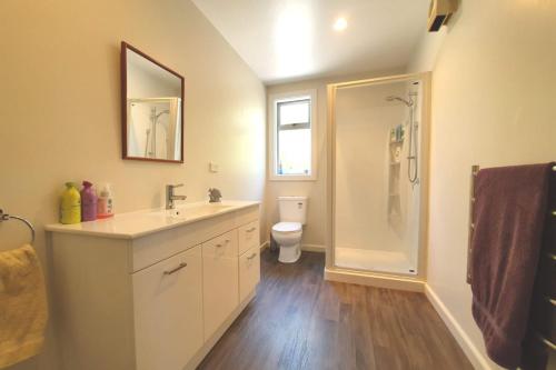a bathroom with a sink and a shower and a toilet at Private Rooms with Shared Bathroom in Lake Tekapo