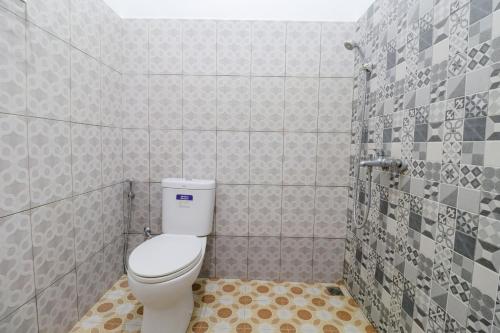 Un pequeño baño con inodoro y ducha. en Penginapan Widodo Syariah Borobudur, en Magelang
