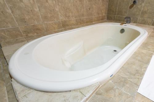 a white bath tub sitting in a bathroom at Boca Inn Hotel & Suites in Veracruz
