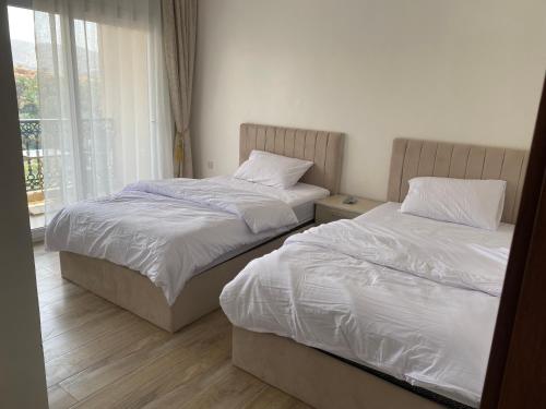 two twin beds in a room with a window at Wadi Bani Khalid Villa in Dawwah