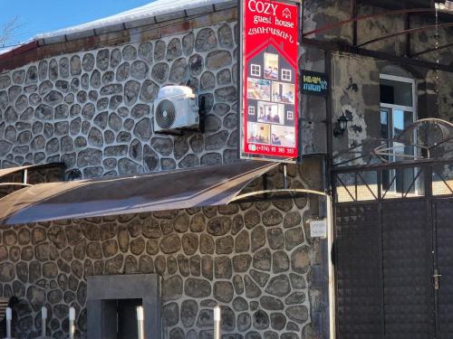 a stone building with a sign on the side of it at COZY guest hous Goris in Goris