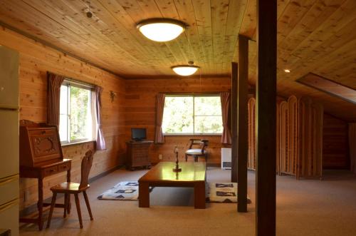 a room with a table in a wooden cabin at Soratobu Usagi in Myoko