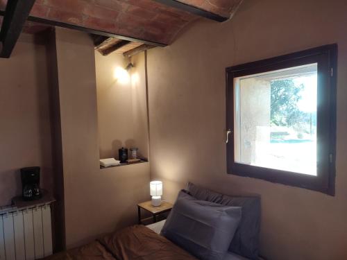 a bedroom with a bed and a window at Podere Rinascidentro in Asciano