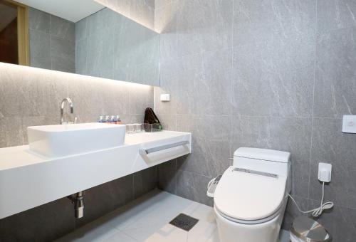 a bathroom with a white toilet and a sink at Eden Paradise Hotel in Icheon