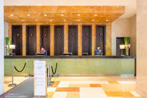 a lobby with two people sitting at a desk at Holiday Inn Xiaoshan by IHG in Hangzhou