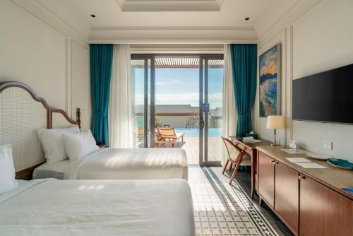 a hotel room with two beds and a television at Edensee Kega Beach Resort in Ke Ga
