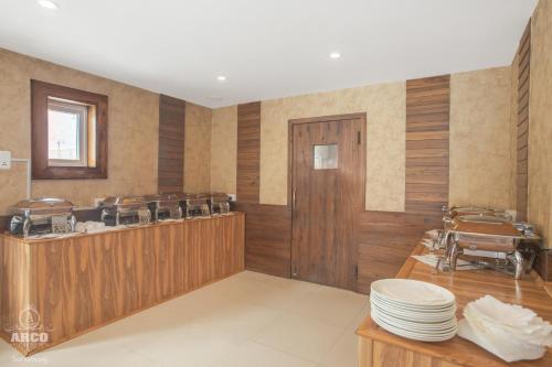 a restaurant with wooden walls and a counter with plates at Arco Hotels & Resorts sonamarg in Sonāmarg