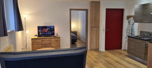 un salon avec une télévision et une cuisine dans l'établissement Meublé du 25 N°5 de tourisme 3*, à Niederbronn-les-Bains