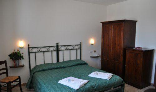 a bedroom with a green bed and a wooden cabinet at Agriturismo Ai Piacentini in Santo Stefano Belbo