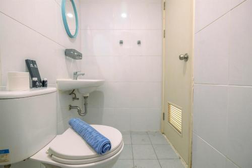 Un baño pequeño con inodoro y lavabo. en Nice and Cozy Studio Apartment at Patraland Urbano By Travelio, en Bekasi