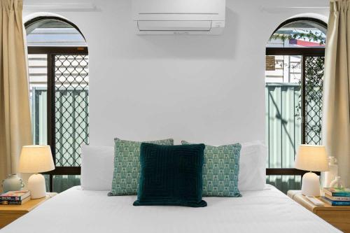 a bedroom with a white bed with green pillows at Spacious Family Getaway in West Leederville in Perth