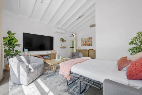 a living room with a bed and a tv at Spacious Family Getaway in West Leederville in Perth