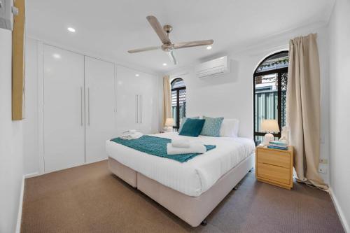 a white bedroom with a bed and two windows at Spacious Family Getaway in West Leederville in Perth