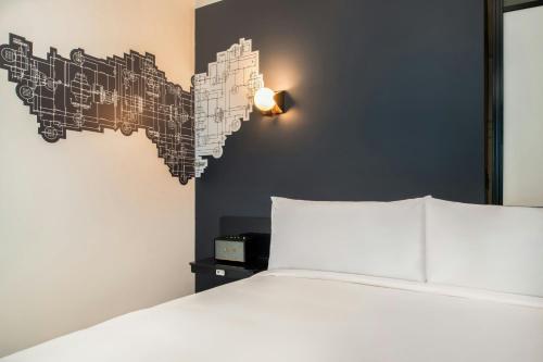 a bedroom with a white bed and a black wall at Aloft Sacramento Airport Natomas in Sacramento