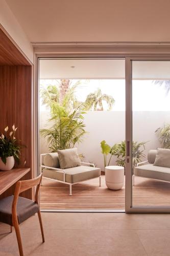 una sala de estar con 2 sofás y una puerta corredera de cristal en The Hide Byron Bay, en Byron Bay