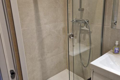 une douche avec une porte vitrée à côté d'un lavabo dans l'établissement Renovated Studio 25m2 Old Town, à Antibes