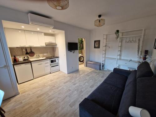 un salon avec un canapé bleu et une cuisine dans l'établissement Renovated Studio 25m2 Old Town, à Antibes