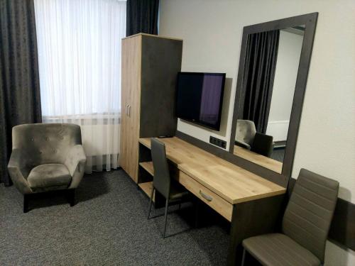 a room with a desk with a television and a mirror at Alfa in Kiliya