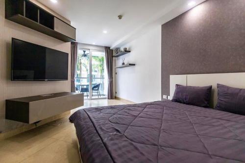 a bedroom with a large purple bed and a flat screen tv at Large luxury condo - Pattaya City Centre - Centara Avenue, Pool View - 217 in Pattaya Central
