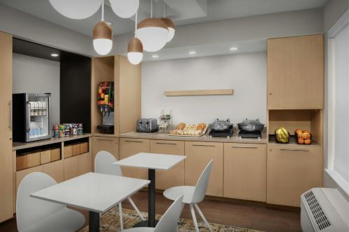 a kitchen with two tables and chairs in a room at TownePlace Suites Pensacola in Pensacola