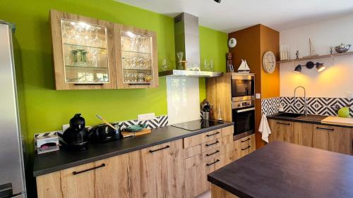- une cuisine avec des placards en bois et des murs verts dans l'établissement ESPRIT BASSIN near train station - Cosy - 2 guests, au Teich