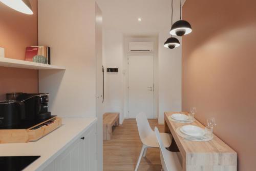 a kitchen with a wooden table and white chairs at Bilo e Mono a 2 passi dall'Ospedale, Centro e Stazione - CasaP17 in Varese