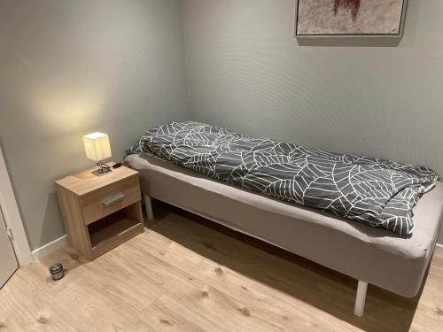un letto con piumone bianco e nero e un tavolino di Rømersgaard a Padborg